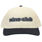 The Dupe Birch/Blue Hat, cream crown with navy brim and navy nine club embroidery, front view